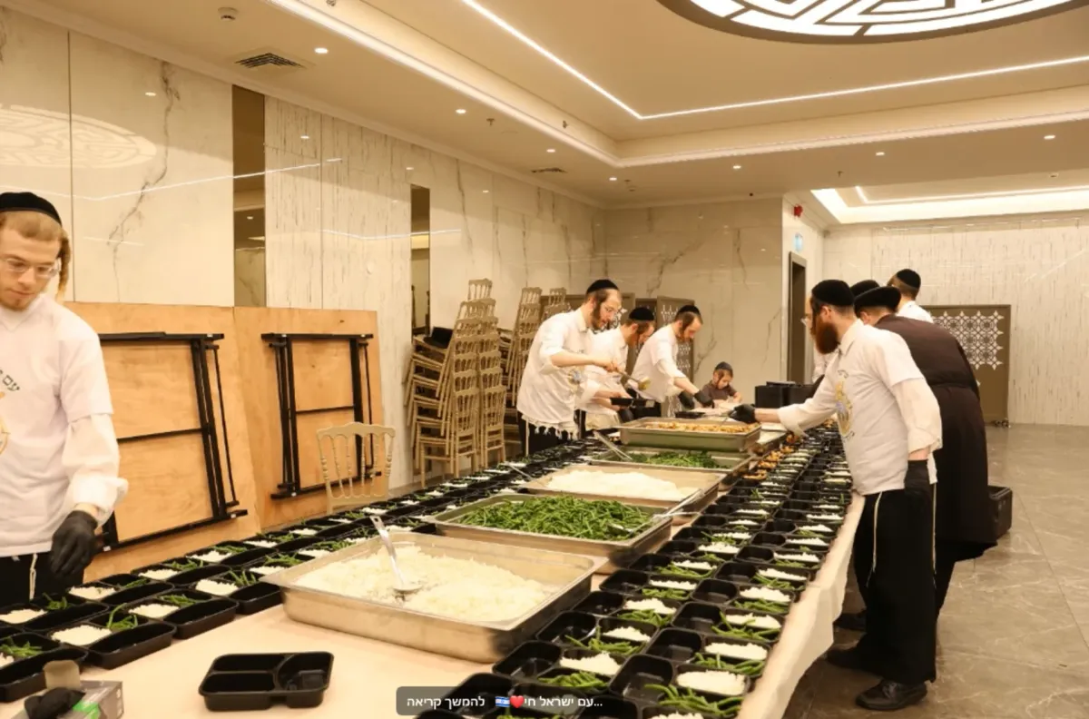 Volunteers packing meals through the Viznitz chesed kitchen